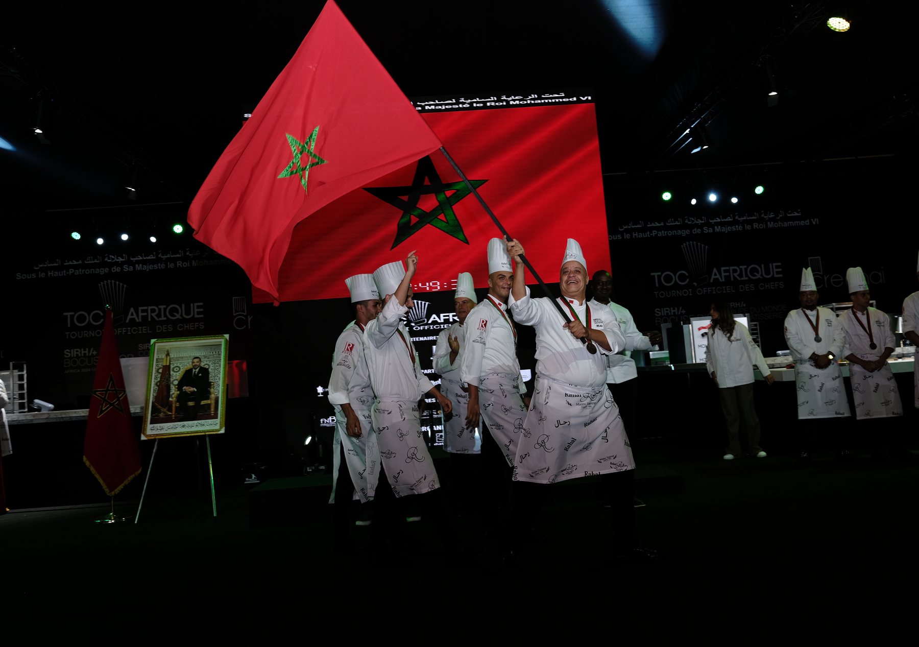 Drapeau marocain déployé sur scène par l'équipe lauréate, TOC Afrique 2024, Marrakech