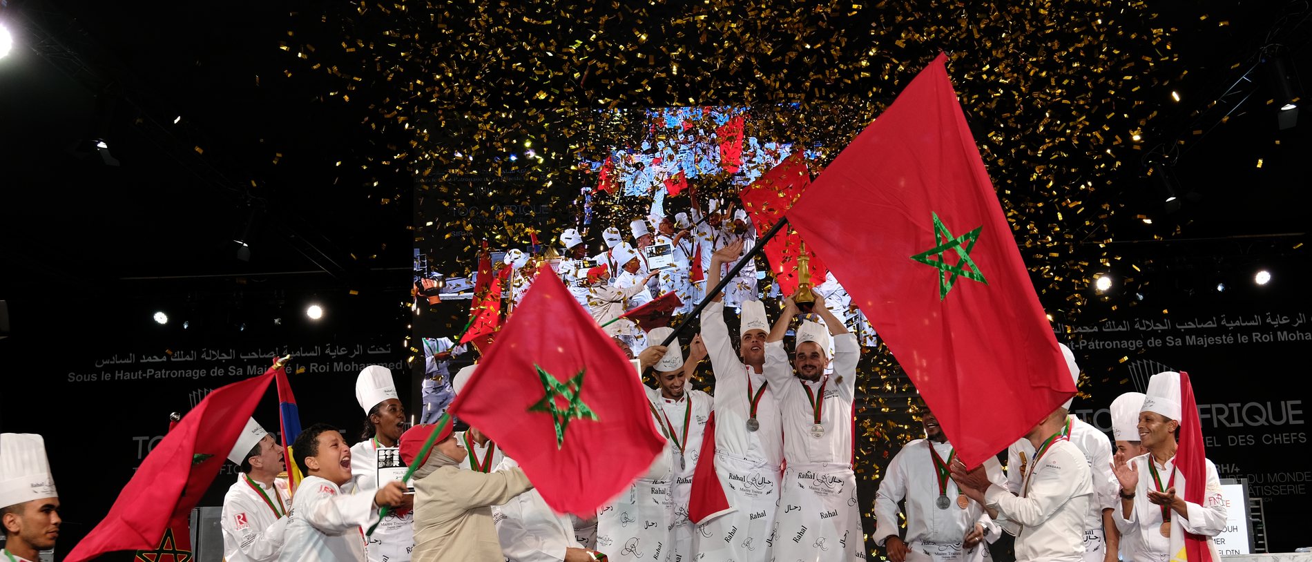 Équipe victorieuse, trophée levé, drapeaux marocains et confettis dorés, Bocuse d'Or Afrique 2024